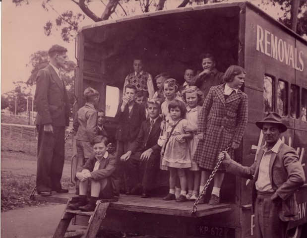Children posing in front of truck at Camp Pell