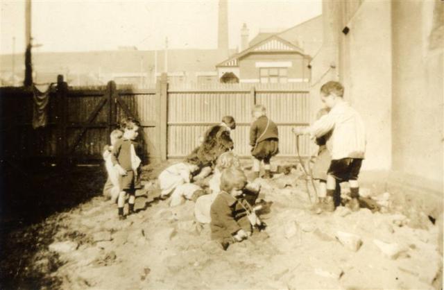 Babies playing on a sand heap