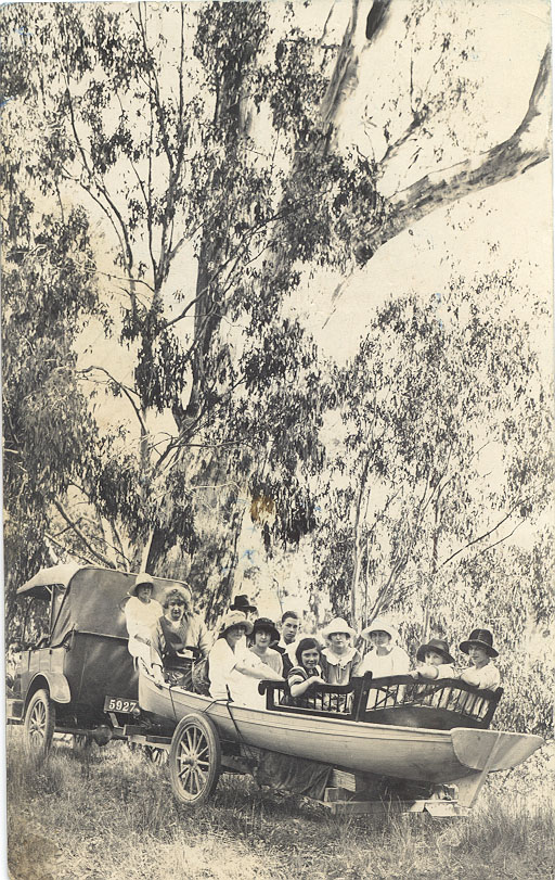 Old car, trailer and boatload of passengers